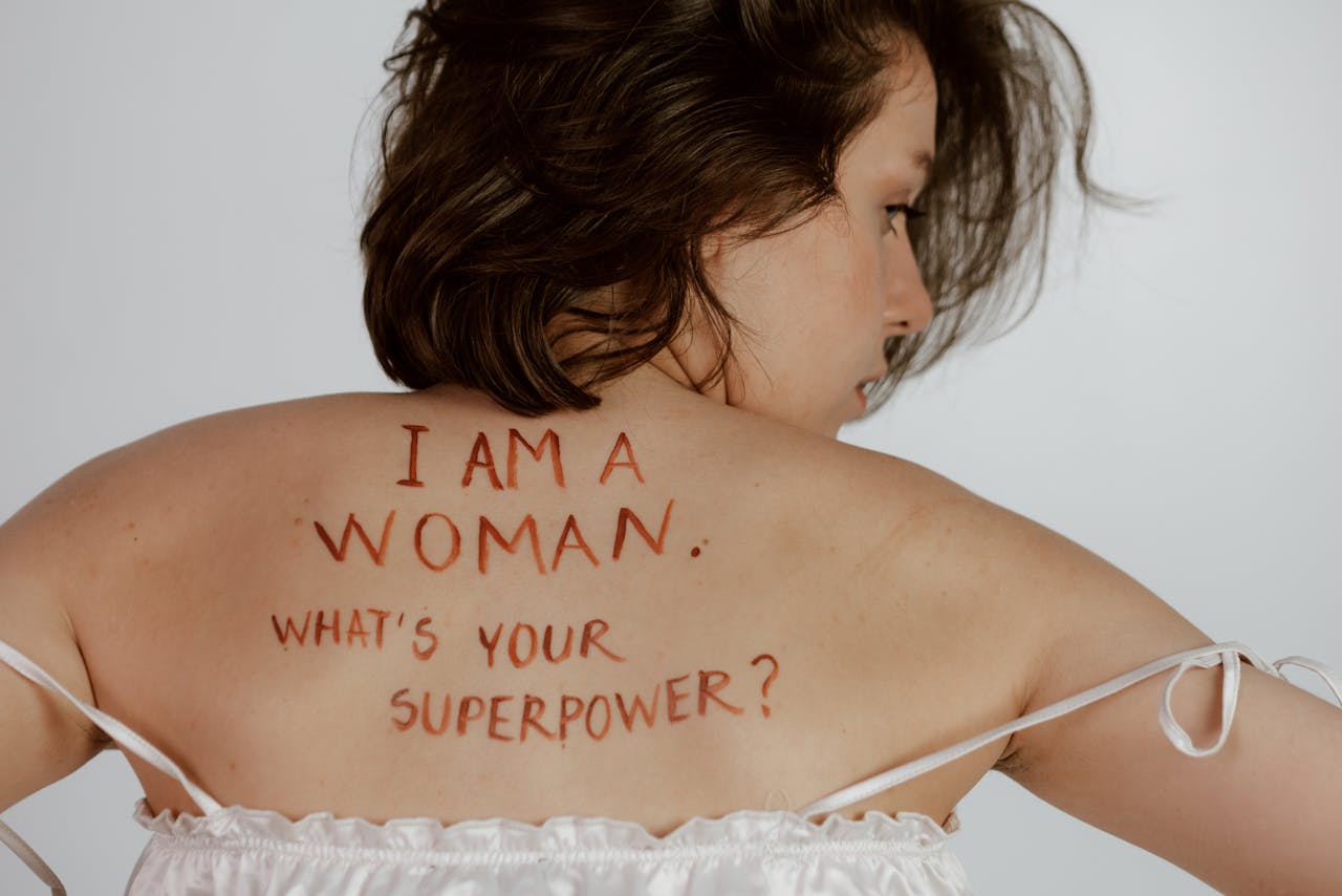why-choose-us Back view of woman with empowering message, promoting self-love and feminism.